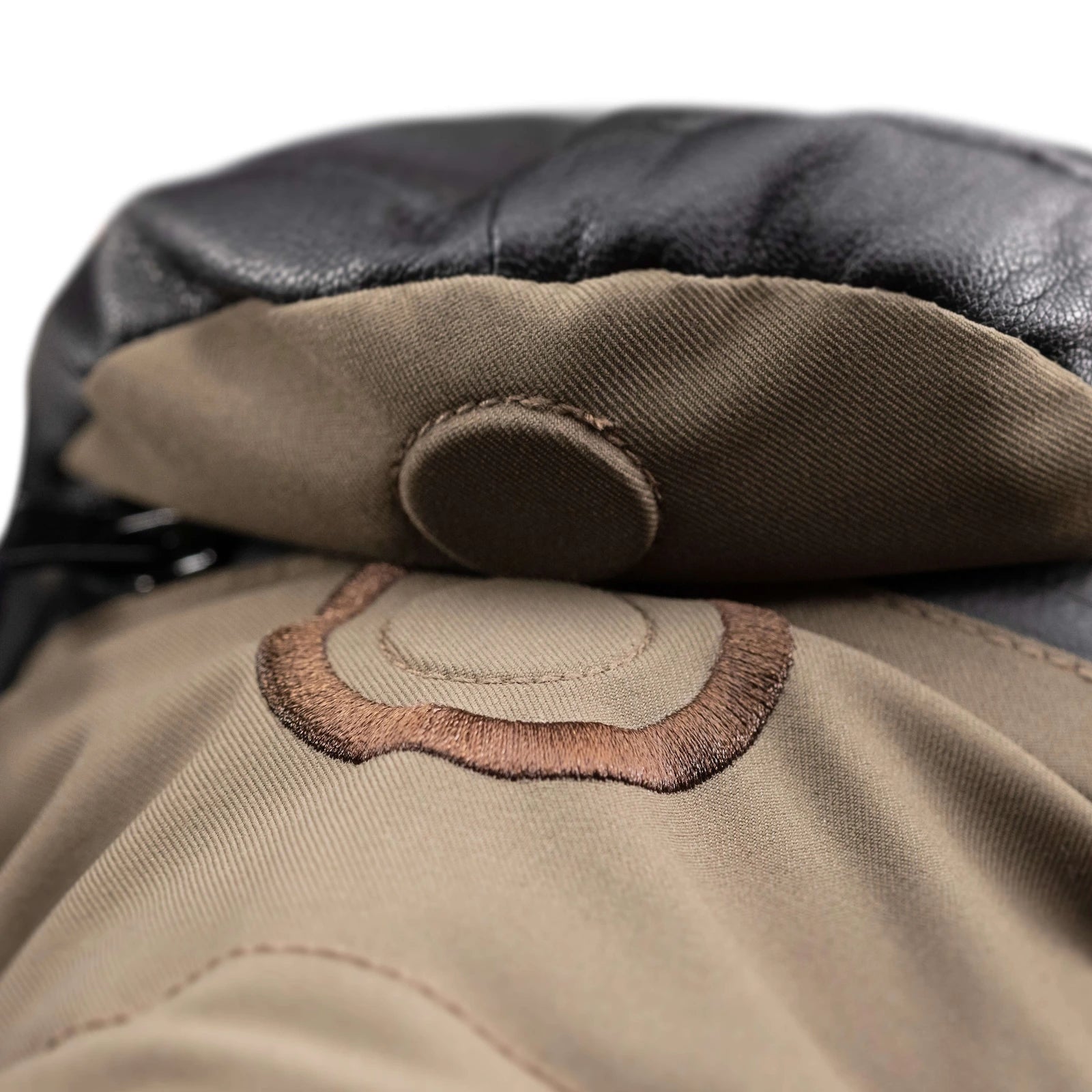 Close-up of a leather mitten Shell on a white background with a magnet button.